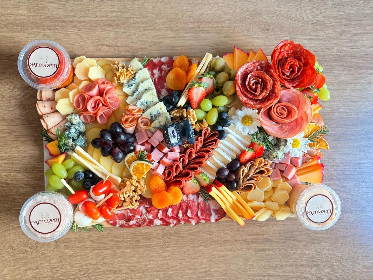 Buffet com mesa longa de frios, queijos e arranjos florais